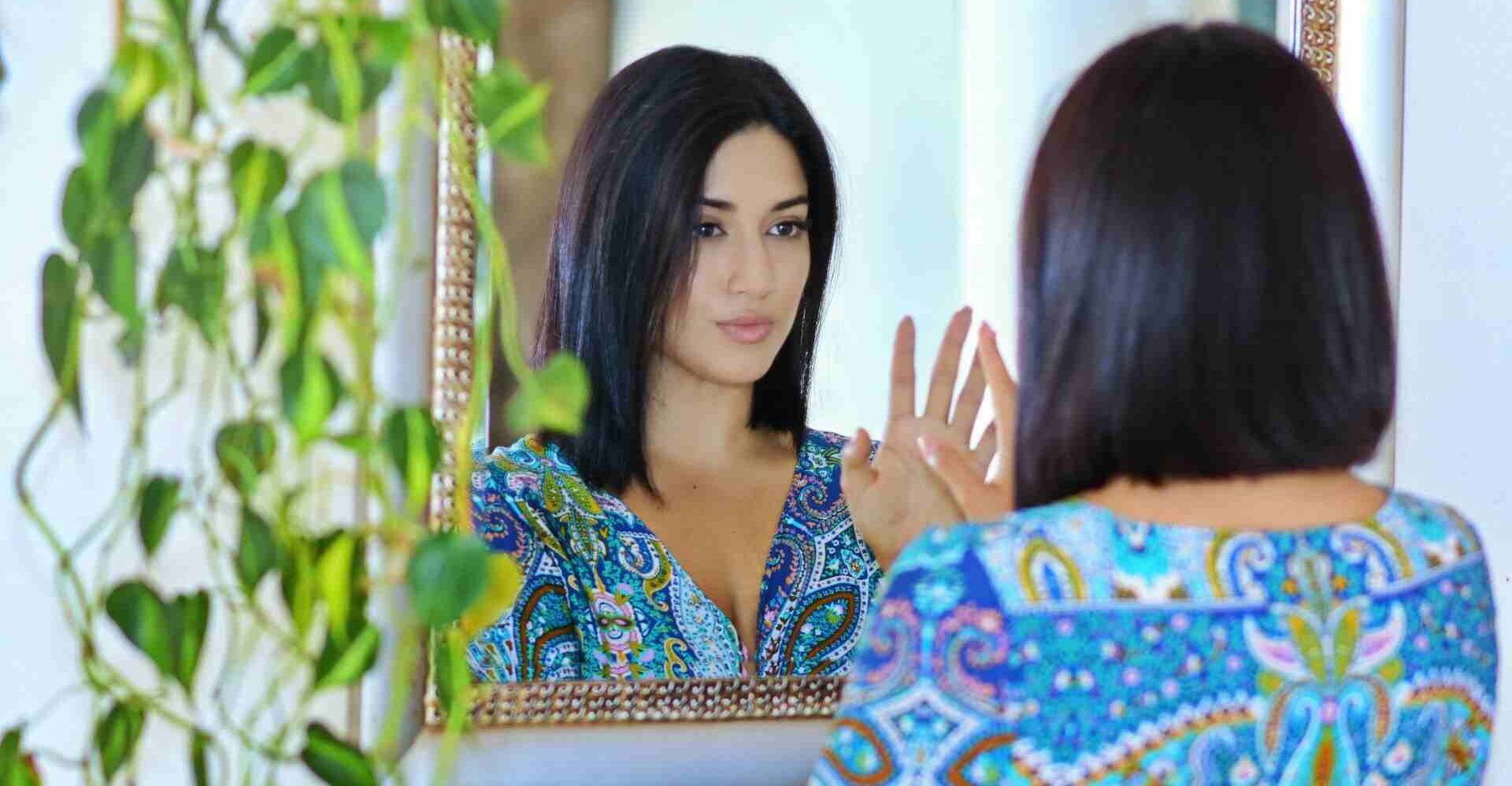 Woman looking at herself in a mirror symbolising different types of narcissists and self-focus traits.